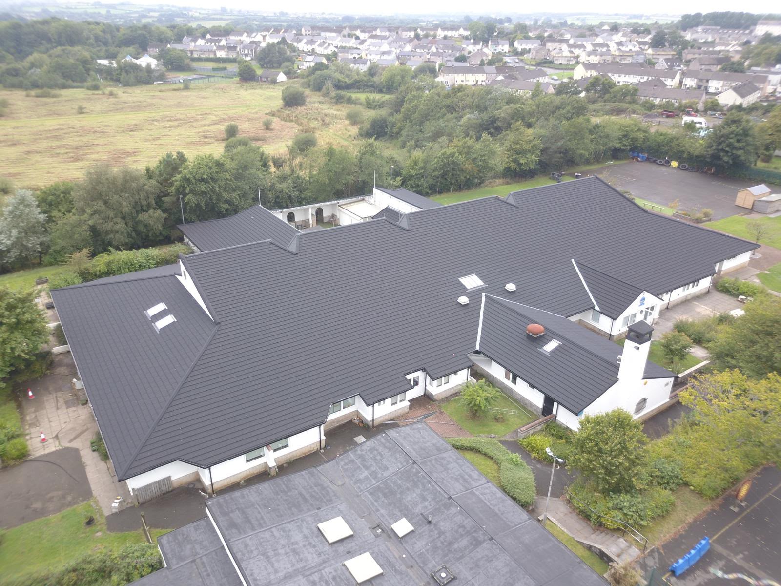 Aerial view of institutional building with new dark tiled roof