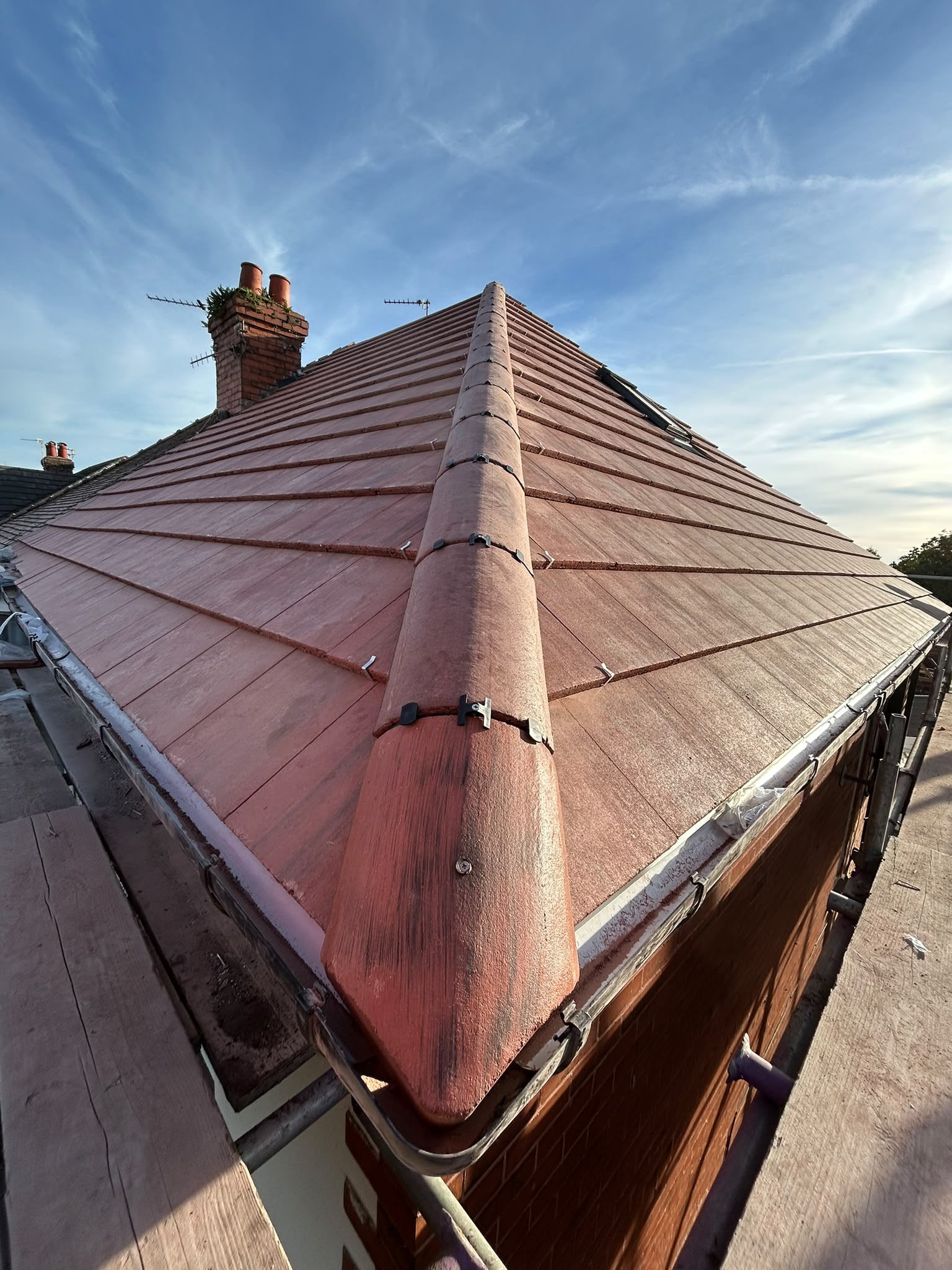 New terracotta roof tiles and dry ridge system on a hip roof