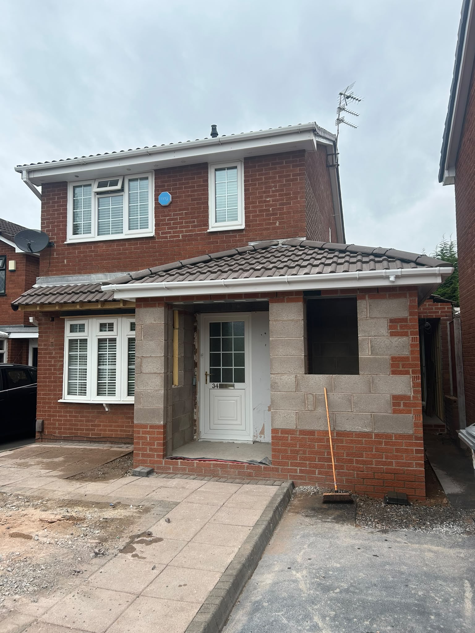 Front elevation with new brown tiled roofs on brick and blockwork
